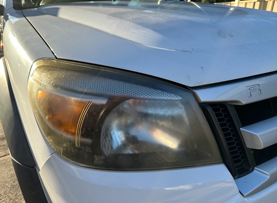 Before — Headlight Restoration — Yellowed headlight restored to a clear finish