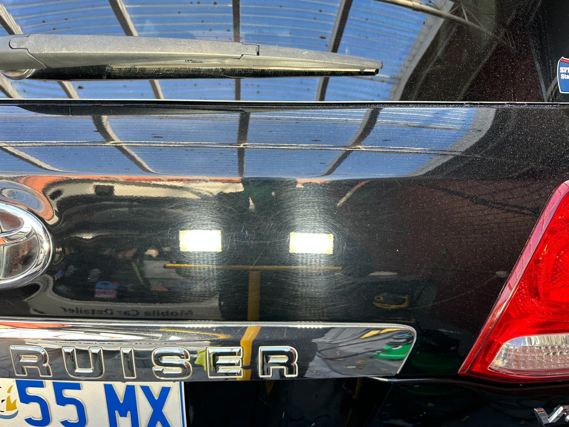 Before — Swirl marks removed from black Toyota paintwork after machine polishing