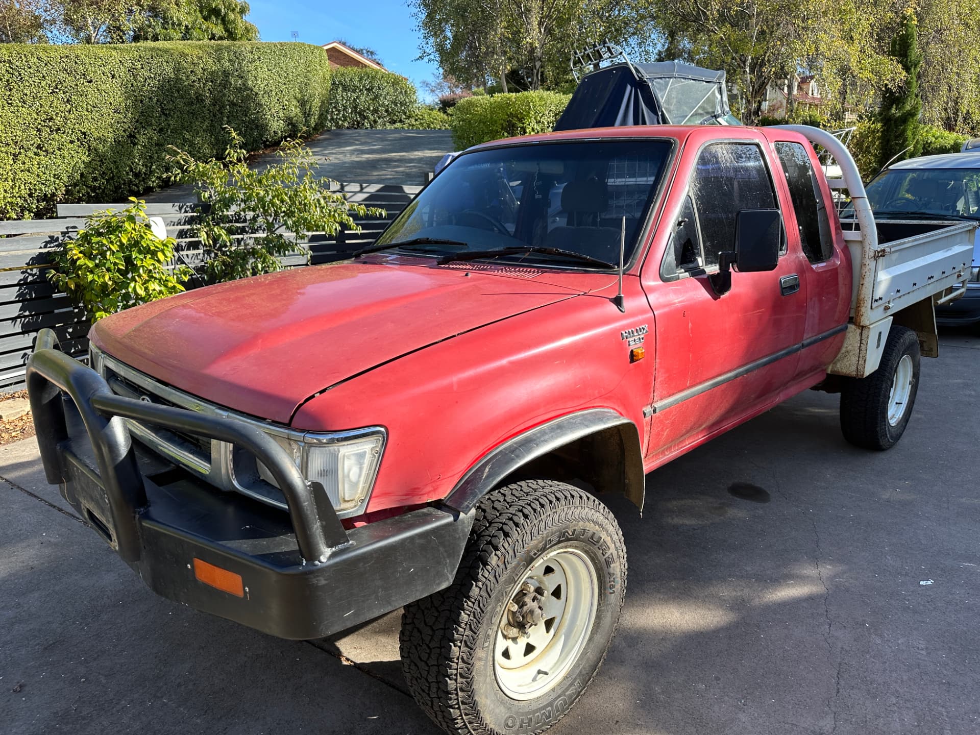 Before — Red Toyota Hilux with faded paint before and after a cut and polish